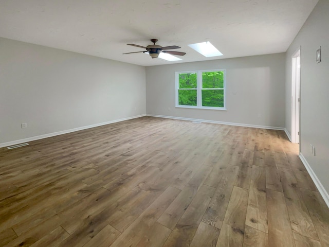 642 Ridenour Rd, Columbus, OH 43230 - spare room featuring wood finished floors, a skylight, a ceiling fan, and baseboards