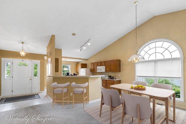 1275 Shelby Cir, Reynoldsburg, OH 43068 - dining room with healthy amount of natural light, baseboards, light carpet, and high vaulted ceiling