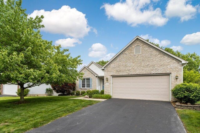 1275 Shelby Cir, Reynoldsburg, OH 43068 - view of front of house featuring driveway, brick siding, a garage, and a front yard