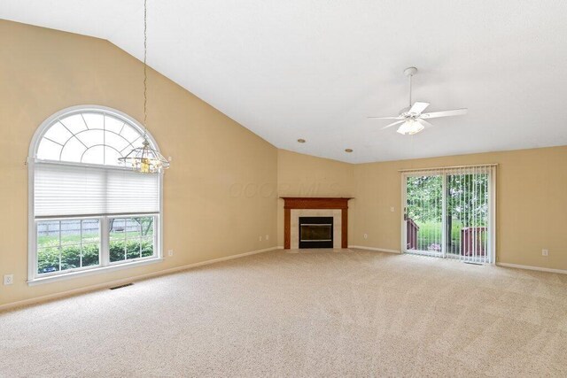 1275 Shelby Cir, Reynoldsburg, OH 43068 - unfurnished living room with lofted ceiling, a ceiling fan, carpet flooring, a tile fireplace, and a chandelier