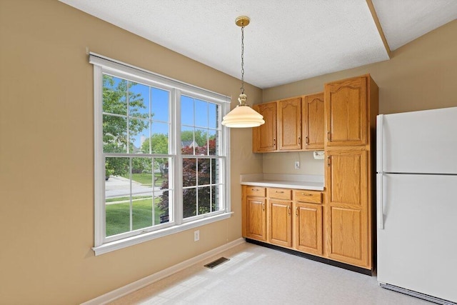 1275 Shelby Cir, Reynoldsburg, OH 43068 - kitchen with freestanding refrigerator, healthy amount of natural light, light countertops, decorative light fixtures, and a textured ceiling