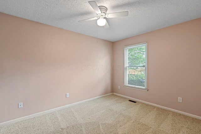 1275 Shelby Cir, Reynoldsburg, OH 43068 - unfurnished room featuring a ceiling fan, light colored carpet, baseboards, and a textured ceiling