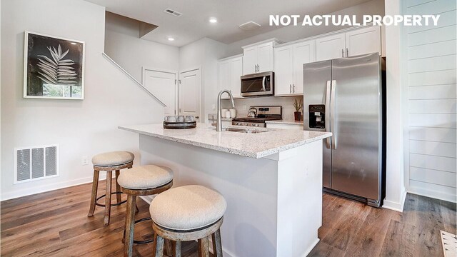 6356 Ripken St, Columbus, OH 43228 - kitchen with stainless steel appliances, dark wood-style floors, a sink, a center island with sink, and baseboards
