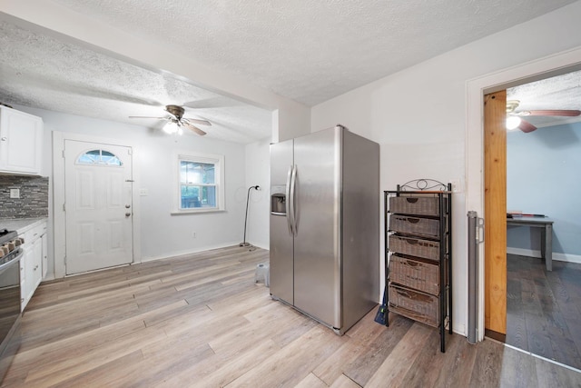 799 E Deshler Ave, Columbus, OH 43206 - kitchen with stainless steel fridge with ice dispenser, a ceiling fan, white cabinets, light wood finished floors, and a textured ceiling