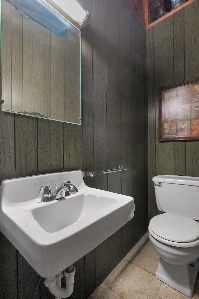 1236 8th Ave, Lancaster, OH 43130 - bathroom featuring wooden walls, toilet, a sink, and tile patterned floors