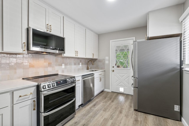 471 Chase Rd, Columbus, OH 43214 - kitchen with stainless steel appliances, a sink, decorative backsplash, light wood-type flooring, and white cabinets