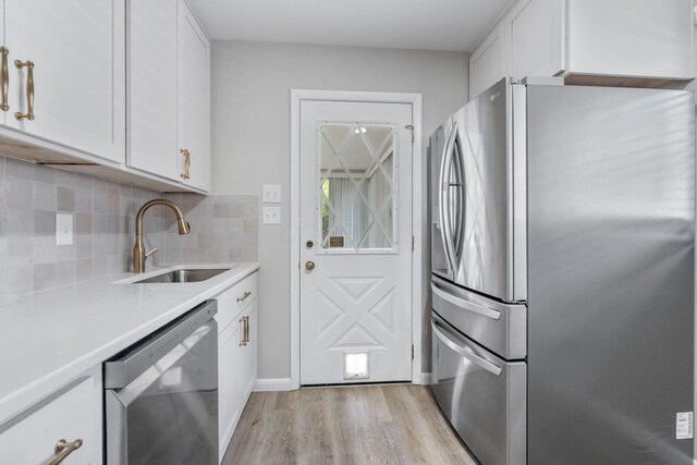 471 Chase Rd, Columbus, OH 43214 - kitchen featuring appliances with stainless steel finishes, a sink, light wood finished floors, and white cabinetry
