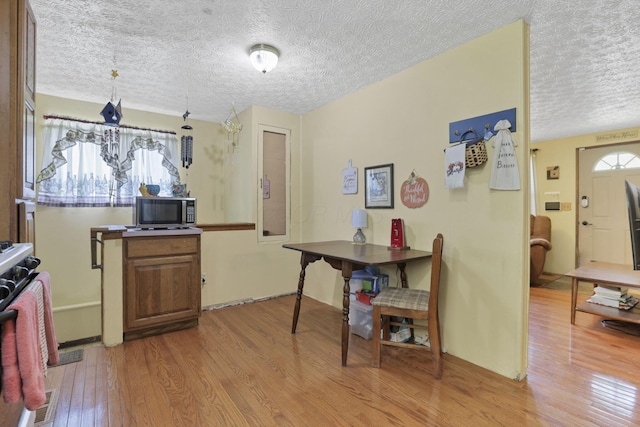dining room with wood finished floors and a textured ceiling