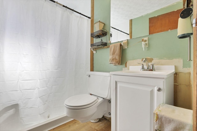 full bath featuring wood finished floors, vanity, a shower with curtain, toilet, and a textured ceiling