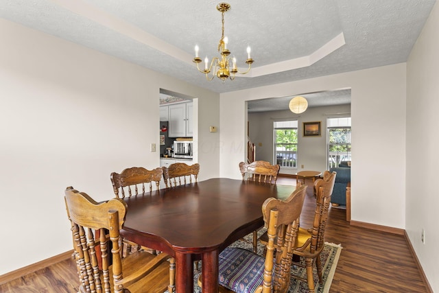 917 Linkfield Dr, Columbus, OH 43085 - dining space featuring a chandelier, a textured ceiling, wood finished floors, baseboards, and a raised ceiling