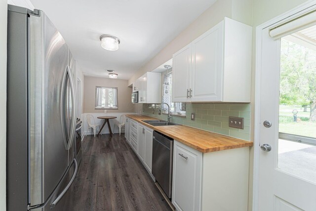 205 Meadowlark Ln, Columbus, OH 43214 - kitchen with stainless steel appliances, a sink, wood counters, white cabinets, and dark wood-style flooring