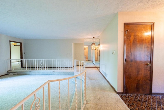 735 Cherrington Rd, Westerville, OH 43081 - hall featuring carpet floors, a chandelier, a textured ceiling, and an upstairs landing