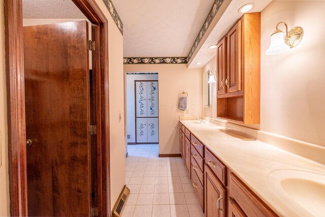 735 Cherrington Rd, Westerville, OH 43081 - bathroom featuring a textured ceiling, double vanity, tile patterned flooring, baseboards, and recessed lighting