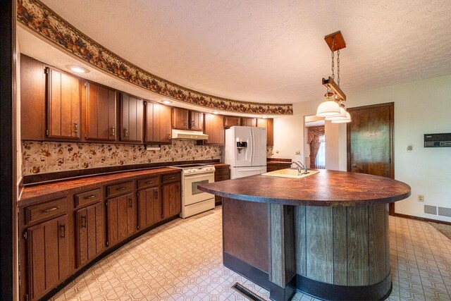 735 Cherrington Rd, Westerville, OH 43081 - kitchen with white appliances, dark countertops, a sink, under cabinet range hood, and a textured ceiling