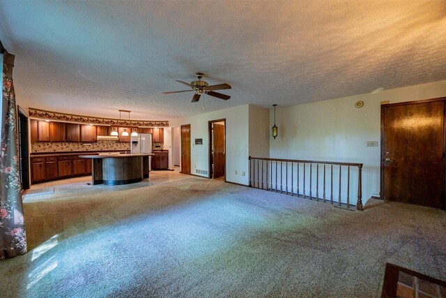 735 Cherrington Rd, Westerville, OH 43081 - unfurnished living room featuring a ceiling fan, a textured ceiling, and light colored carpet