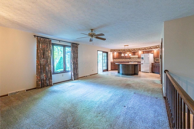 735 Cherrington Rd, Westerville, OH 43081 - unfurnished living room featuring ceiling fan, light colored carpet, a textured ceiling, and baseboards