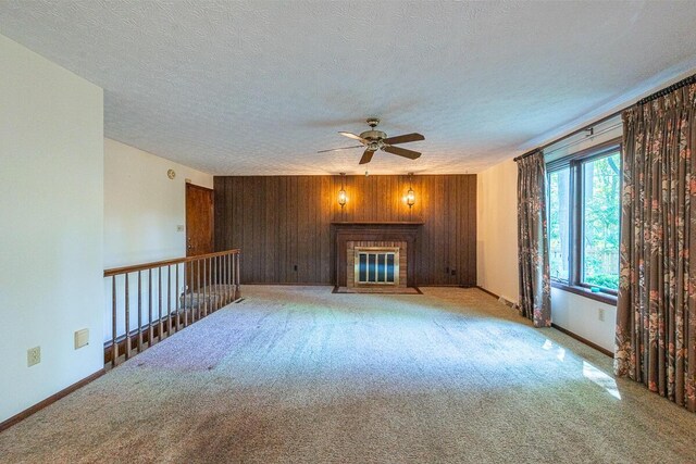 735 Cherrington Rd, Westerville, OH 43081 - unfurnished living room with a ceiling fan, wood walls, a textured ceiling, carpet floors, and a fireplace with flush hearth