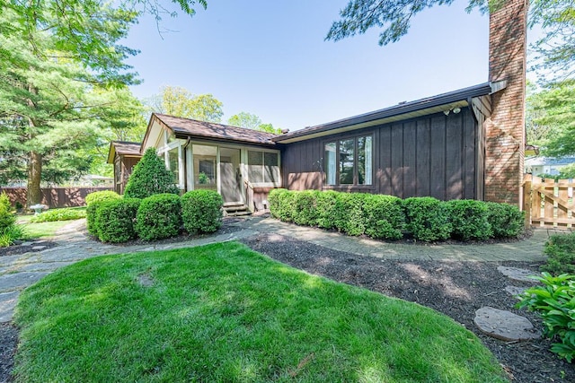 735 Cherrington Rd, Westerville, OH 43081 - view of front facade featuring board and batten siding, a chimney, and a sunroom