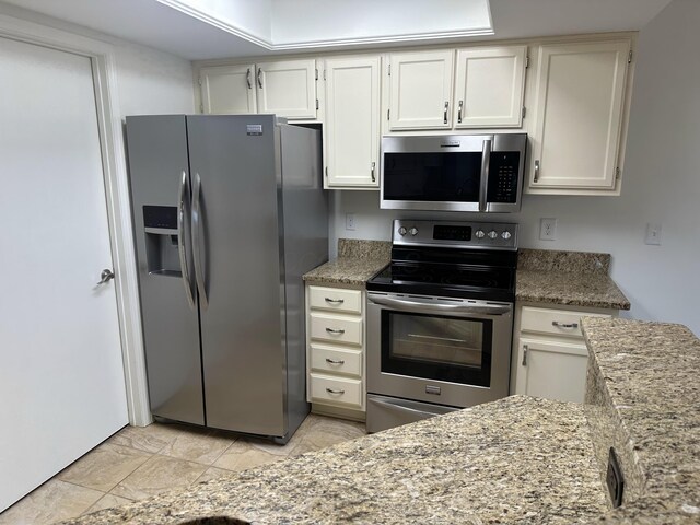 6667 Heatherstone Loop, Dublin, OH 43017 - kitchen featuring appliances with stainless steel finishes, light stone countertops, and white cabinets