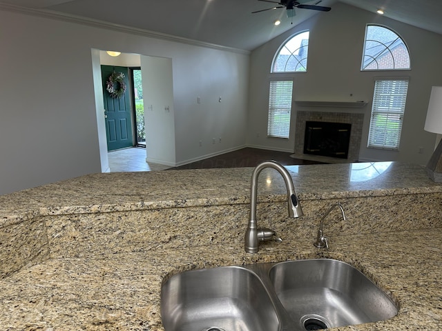 6667 Heatherstone Loop, Dublin, OH 43017 - kitchen with a sink, ceiling fan, plenty of natural light, a fireplace, and vaulted ceiling