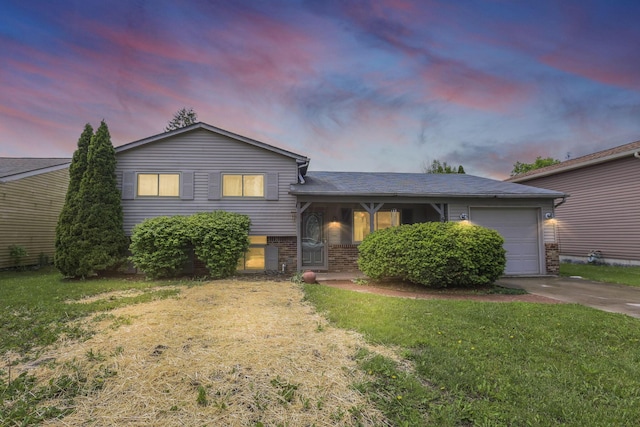 1703 Ringfield Dr, Galloway, OH 43119 - split level home with driveway, a garage, a front yard, and brick siding