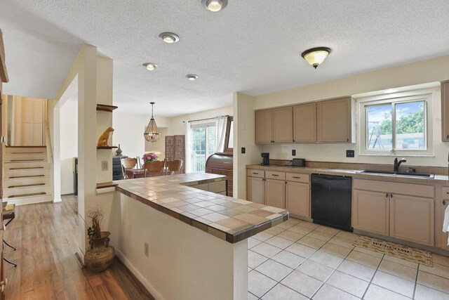 1703 Ringfield Dr, Galloway, OH 43119 - kitchen featuring a sink, black dishwasher, tile counters, a peninsula, and pendant lighting