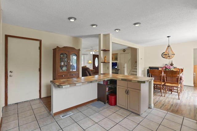 1703 Ringfield Dr, Galloway, OH 43119 - kitchen with tile countertops, light tile patterned floors, a textured ceiling, pendant lighting, and a ceiling fan