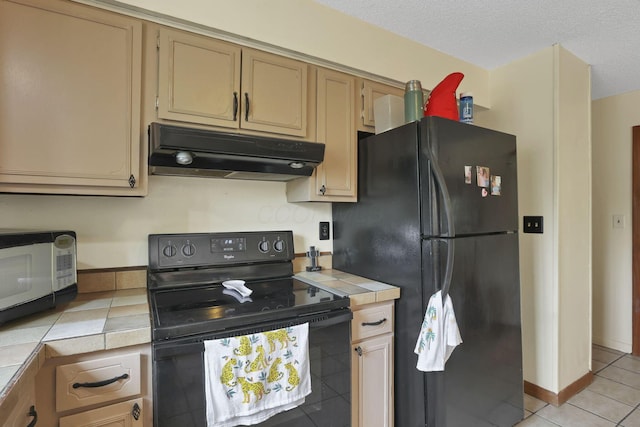 1703 Ringfield Dr, Galloway, OH 43119 - kitchen featuring tile countertops, black appliances, under cabinet range hood, light tile patterned floors, and a textured ceiling