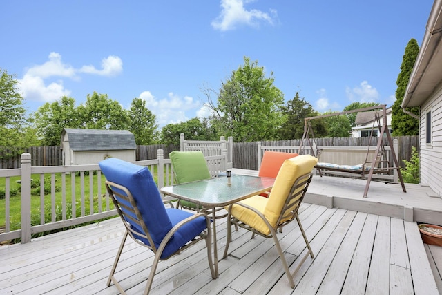 1703 Ringfield Dr, Galloway, OH 43119 - wooden deck featuring a fenced backyard, outdoor dining space, a storage unit, and an outdoor structure
