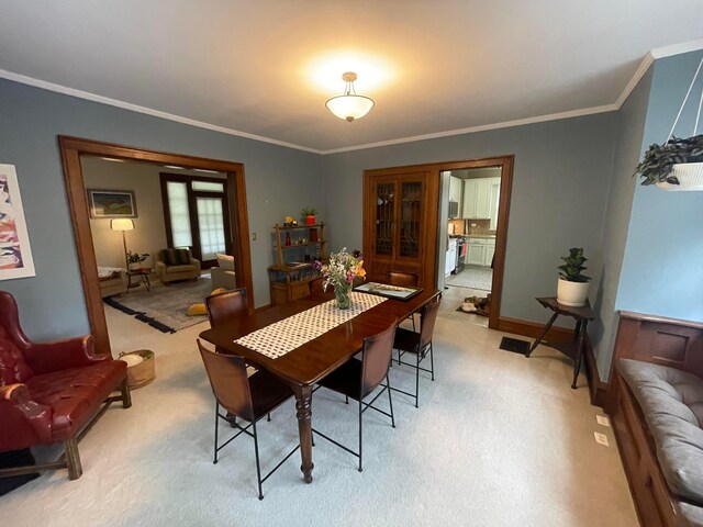 91 Oakland Park Ave, Columbus, OH 43214 - dining room with light carpet, ornamental molding, and baseboards