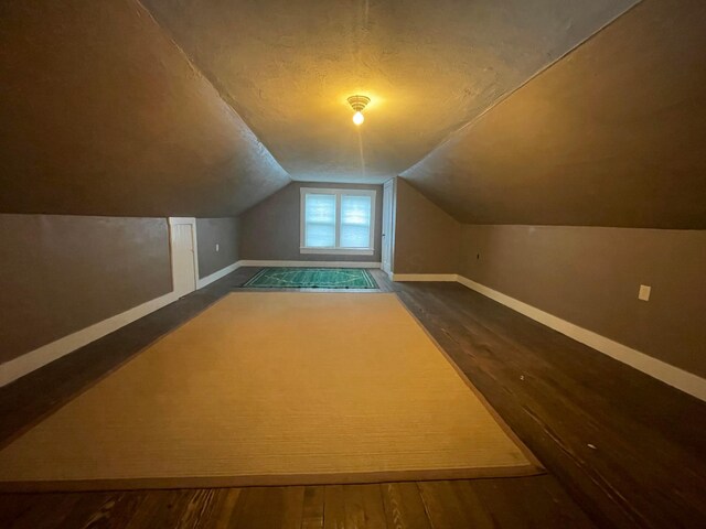 91 Oakland Park Ave, Columbus, OH 43214 - bonus room featuring baseboards, vaulted ceiling, dark wood-style flooring, and a textured ceiling
