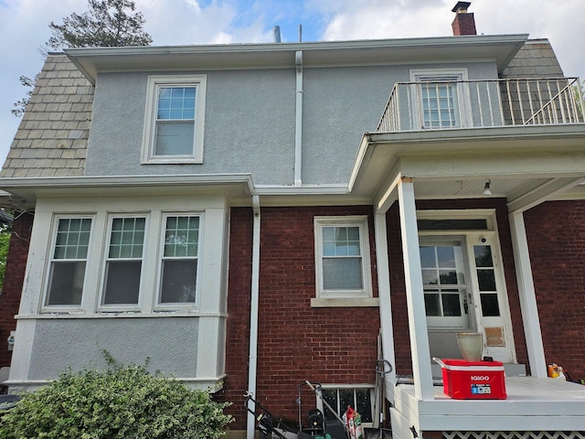 91 Oakland Park Ave, Columbus, OH 43214 - view of side of property with a balcony, brick siding, and a chimney