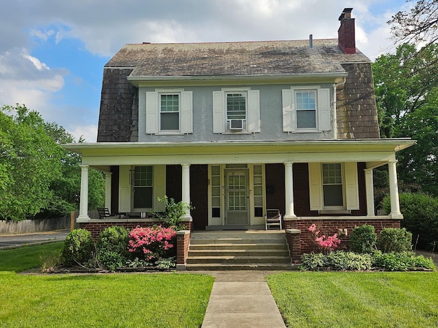 91 Oakland Park Ave, Columbus, OH 43214 - view of front of home with a chimney, a front yard, covered porch, and brick siding