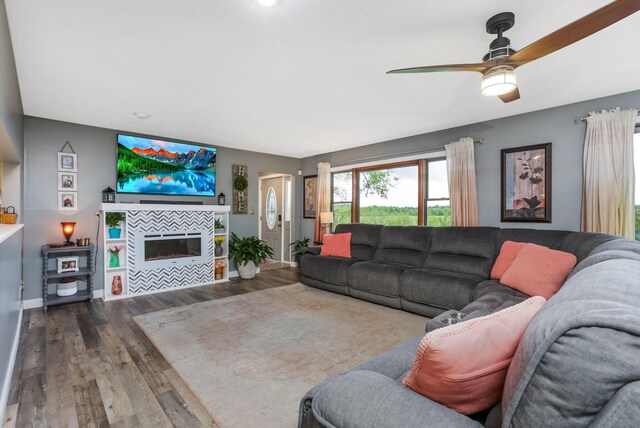 8485 Benson Rd NW, Carroll, OH 43112 - living room with ceiling fan, wood finished floors, a tiled fireplace, and baseboards