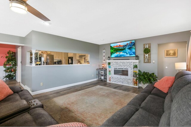 8485 Benson Rd NW, Carroll, OH 43112 - living area featuring wood finished floors, baseboards, ceiling fan, and a tiled fireplace