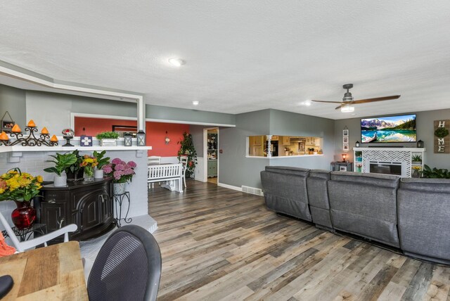8485 Benson Rd NW, Carroll, OH 43112 - living room featuring wood finished floors, a tiled fireplace, ceiling fan, baseboards, and recessed lighting