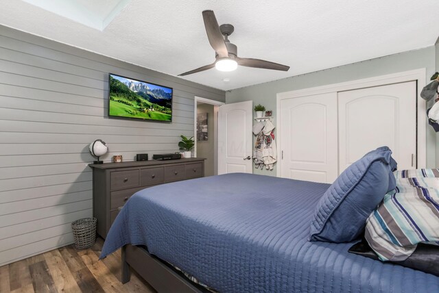 8485 Benson Rd NW, Carroll, OH 43112 - bedroom with wood finished floors, a closet, a ceiling fan, wood walls, and a textured ceiling