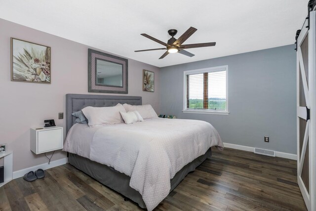 8485 Benson Rd NW, Carroll, OH 43112 - bedroom with a barn door, wood finished floors, baseboards, and a ceiling fan