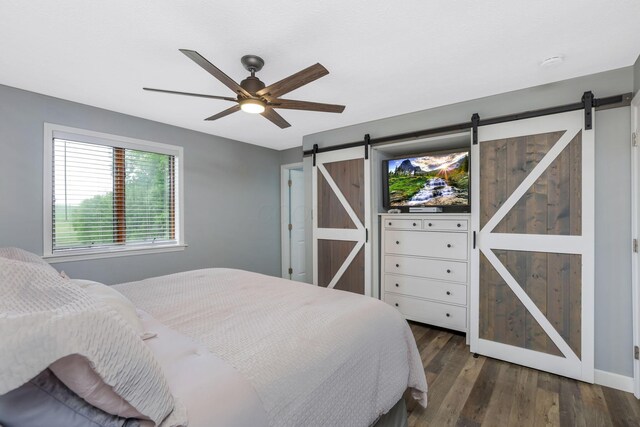 8485 Benson Rd NW, Carroll, OH 43112 - bedroom featuring a barn door, wood finished floors, a ceiling fan, and baseboards
