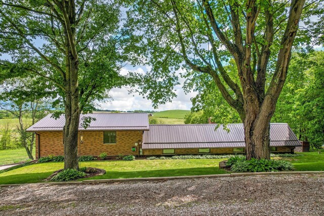 8485 Benson Rd NW, Carroll, OH 43112 - view of property exterior with metal roof, a lawn, a standing seam roof, and brick siding