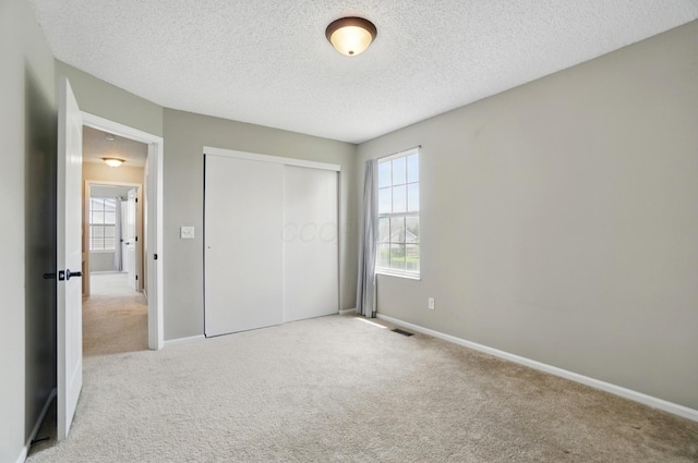 5199 Goldfield Dr, Hilliard, OH 43026 - unfurnished bedroom featuring carpet floors, baseboards, a closet, and a textured ceiling