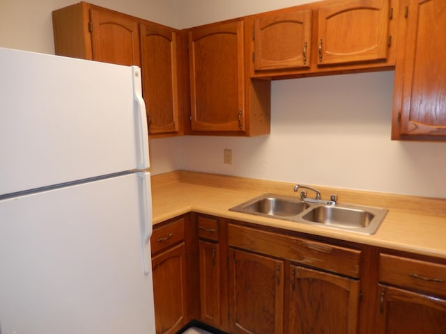 4143 Karl Rd Unit 214, Columbus, OH 43224 - kitchen featuring freestanding refrigerator, a sink, light countertops, and brown cabinets