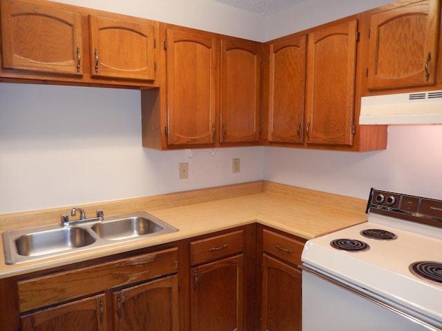 4143 Karl Rd Unit 214, Columbus, OH 43224 - kitchen with white range with electric cooktop, under cabinet range hood, light countertops, a sink, and brown cabinets