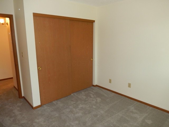4143 Karl Rd Unit 214, Columbus, OH 43224 - unfurnished bedroom featuring carpet floors, a closet, and baseboards