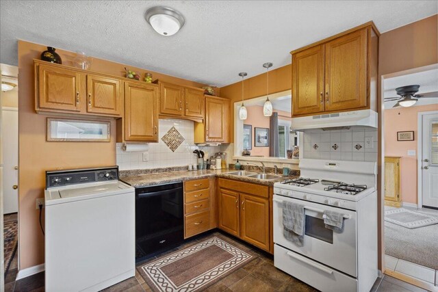 1200 Northridge Rd, Columbus, OH 43224 - kitchen with white gas range oven, washer / dryer, under cabinet range hood, black dishwasher, and backsplash