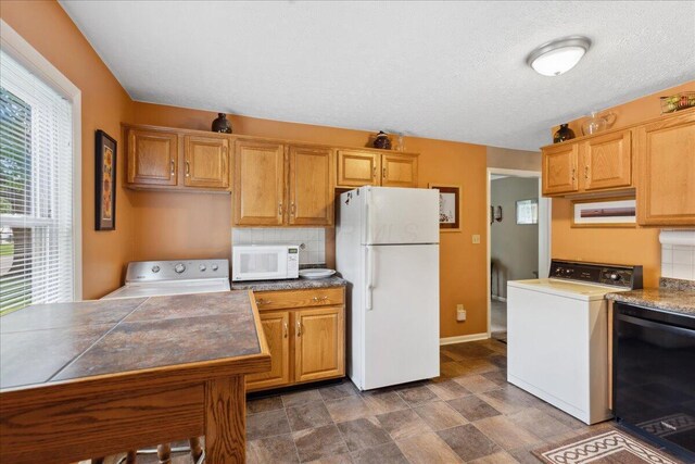 1200 Northridge Rd, Columbus, OH 43224 - kitchen with white appliances, washer / clothes dryer, baseboards, and stone finish flooring
