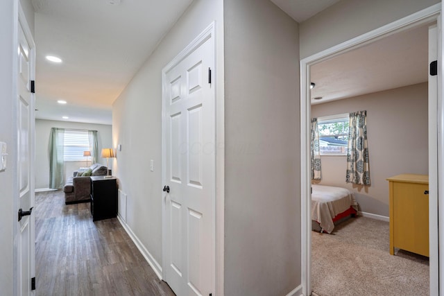 corridor with baseboards, recessed lighting, and wood finished floors