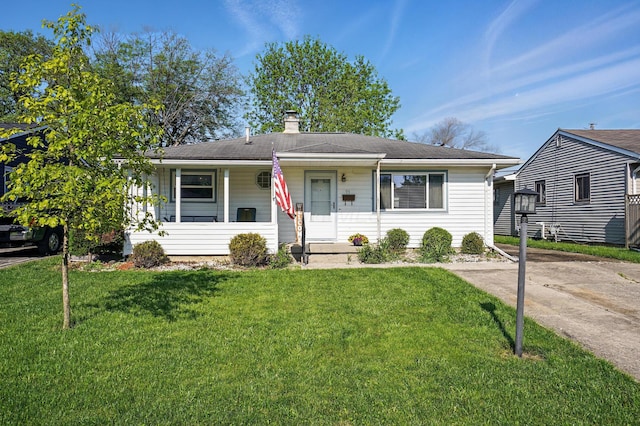 view of front of property featuring a front lawn, a chimney, and a porch