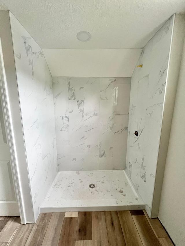 818 Bellows Ave, Columbus, OH 43223 - bathroom with wood finished floors, a marble finish shower, a textured ceiling, and vaulted ceiling