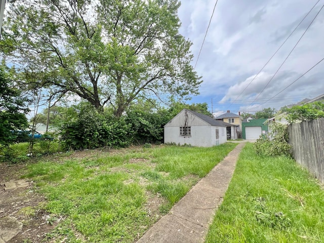 818 Bellows Ave, Columbus, OH 43223 - view of yard featuring a detached garage, fence, driveway, and an outbuilding